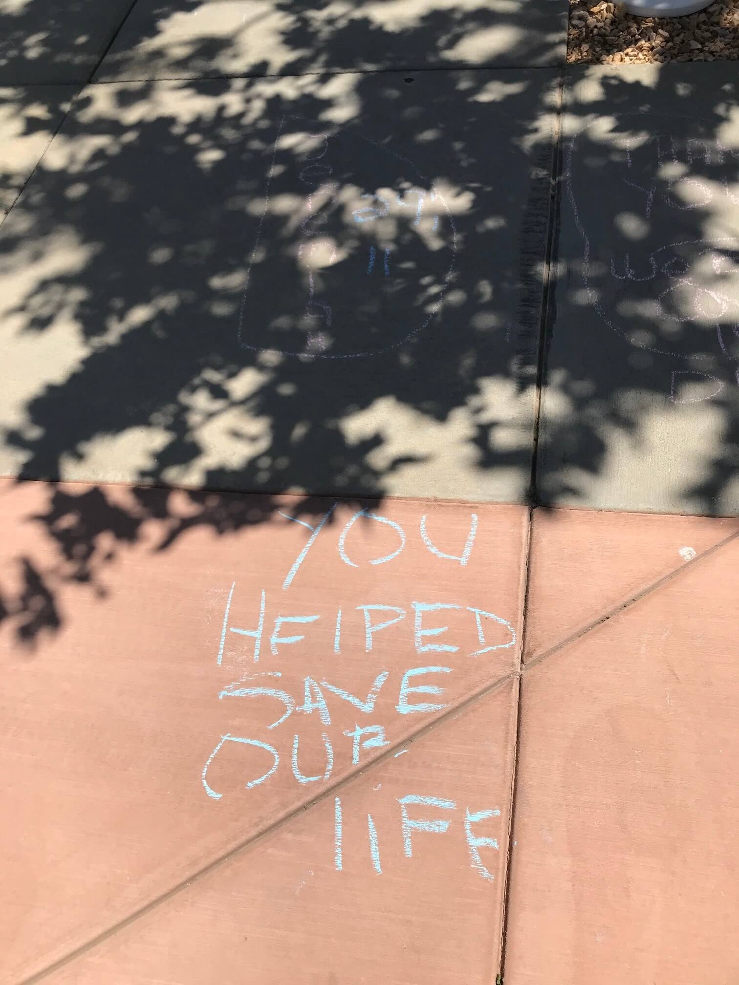 Chalk drawing that says "you helped save our life"